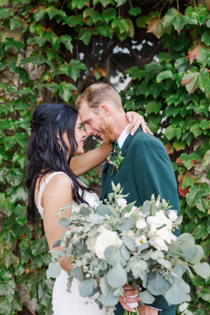 A bride and groom pose in front of an ivy wall. 

Central Illinois Wedding Photographer.

Amanda Banik Photography