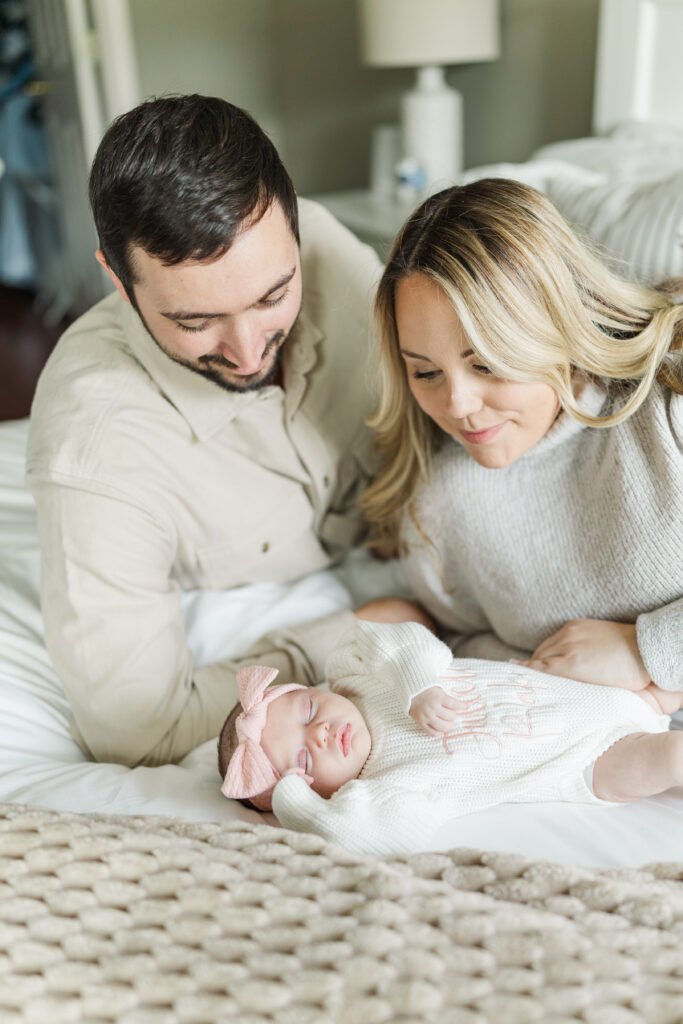 Mom and dad smile down at their newborn baby during their in home newborn session.
Central Illinois Newborn Photographer.
Amanda Banik Photography