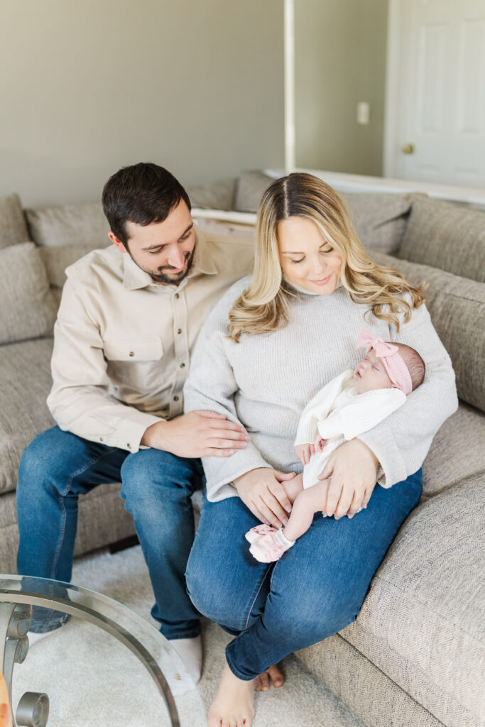 A mom and dad sit on the couch holding their baby girl.
Central Illinois Newborn Photographer.
Amanda Banik Photography