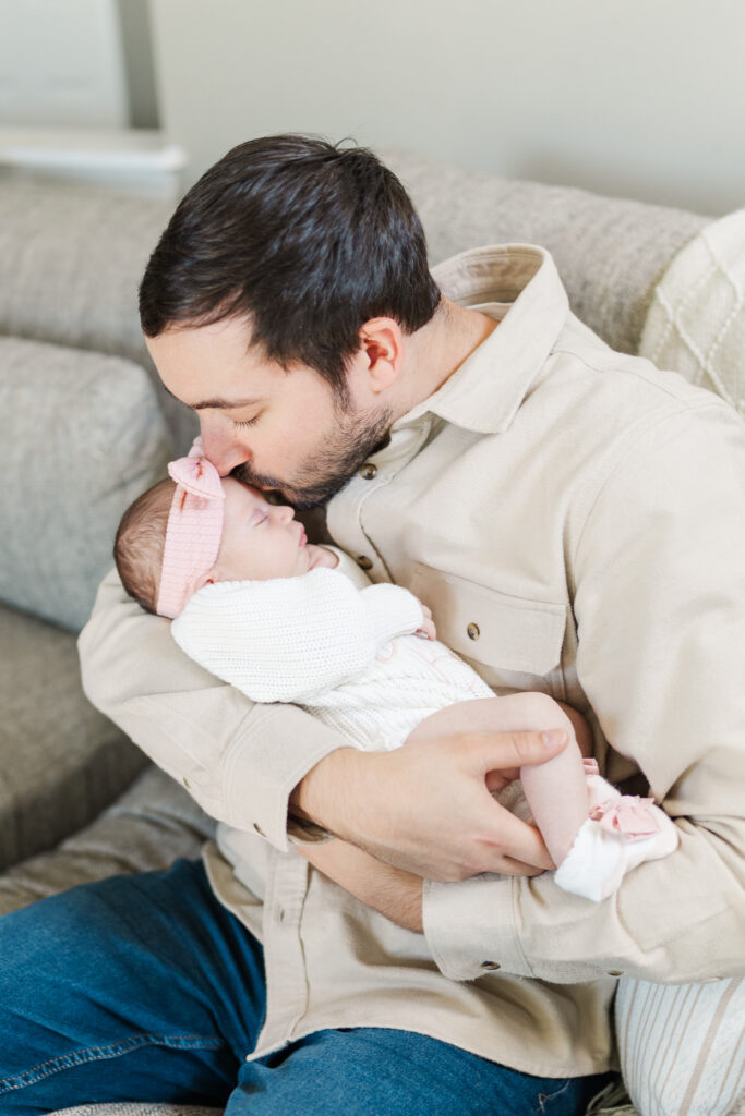 A dad proudly kisses his baby girl. Central Illinois Newborn Photographer. Amanda Banik Photography