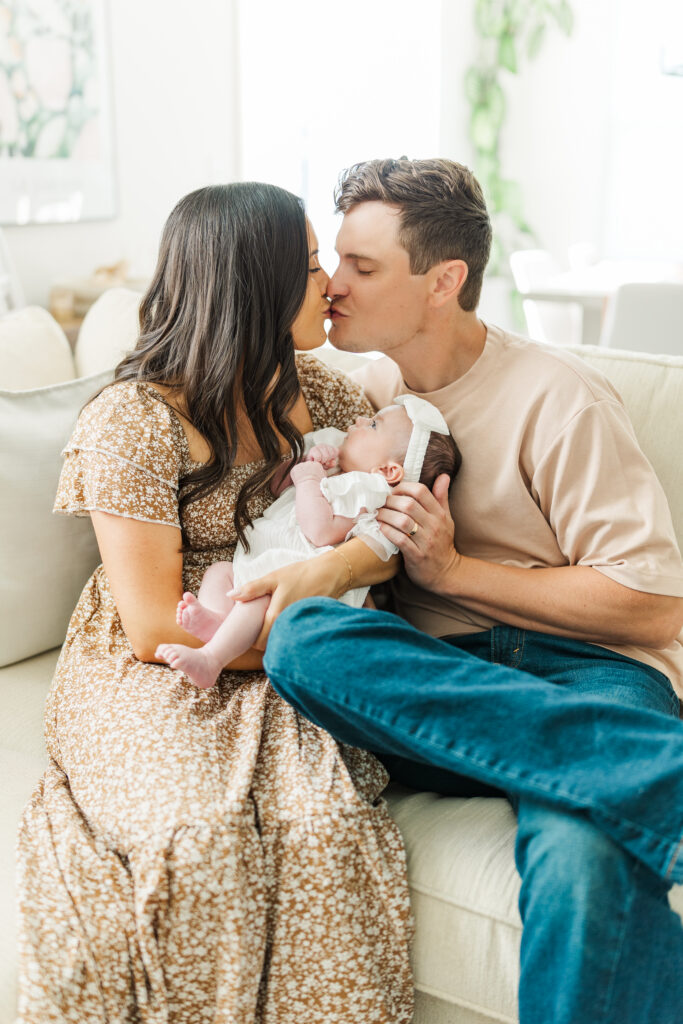Two new parents kiss while holding their baby.

Central Illinois In-Home Newborn Session.

Photos by Amanda Banik Photography